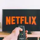 person holding remote pointing at TV