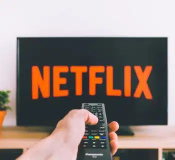 person holding remote pointing at TV