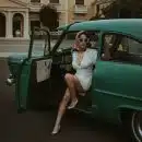 a woman sitting in the back of a green car