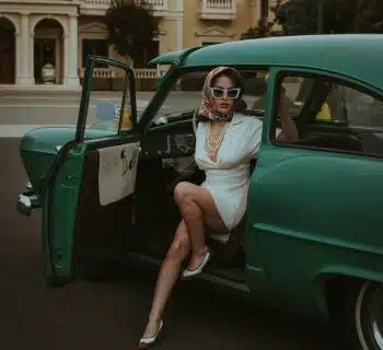 a woman sitting in the back of a green car