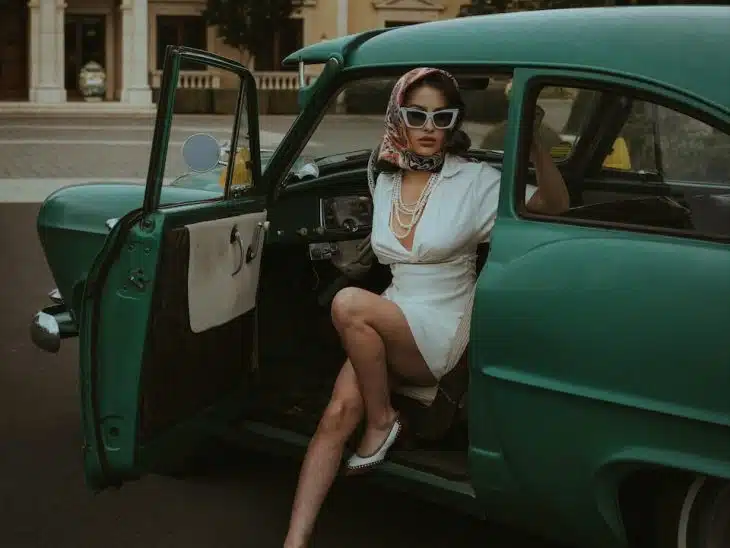 a woman sitting in the back of a green car