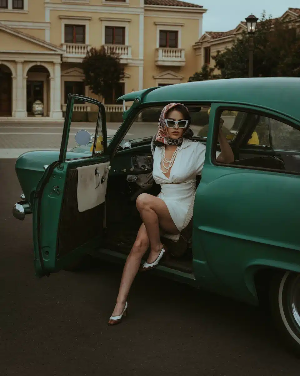 a woman sitting in the back of a green car