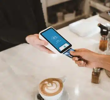 person putting magstripe card near black card terminal