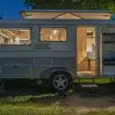 white and brown camper trailer beside tree